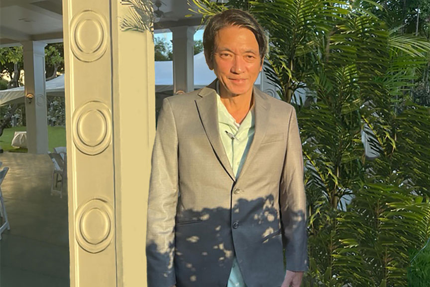 man in gray suit standing in sun outside