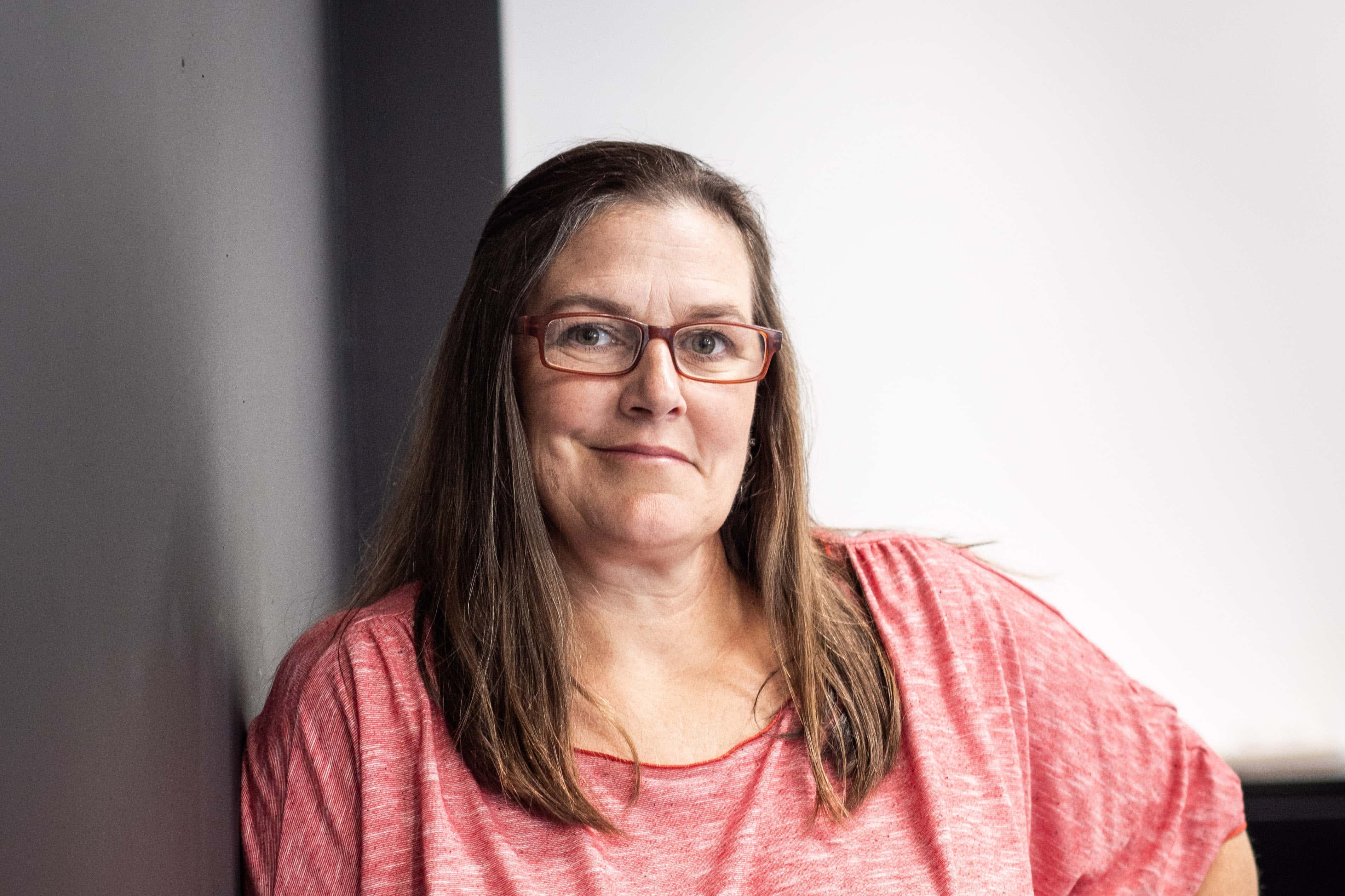 woman in glasses wearing pink shirt